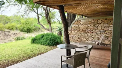 a patio with a table and chairs on a porch at Simbavati Camp George in Klaserie Private Nature Reserve