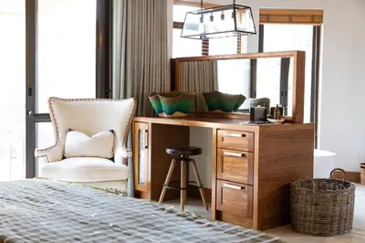 a bedroom with a desk with a mirror and a chair at Simbavati Camp George in Klaserie Private Nature Reserve