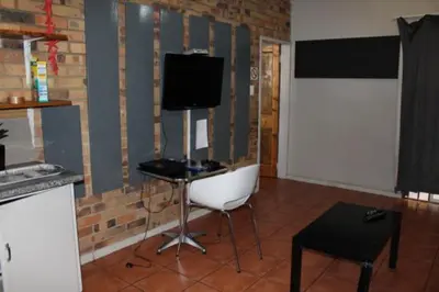 a living room with a chair and a television at 94onWild in Pretoria