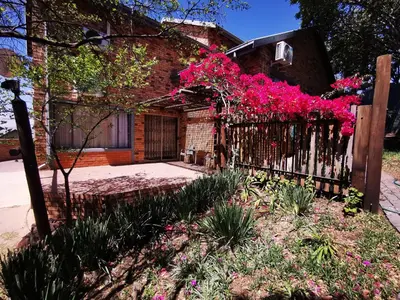 a house with pink flowers on a fence at 94onWild in Pretoria