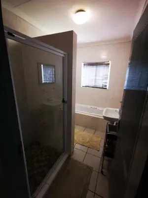 a bathroom with a shower and a sink at 94onWild in Pretoria