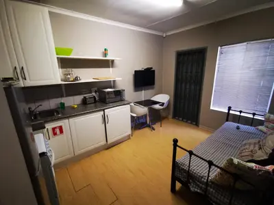 a room with a kitchen and a living room at 94onWild in Pretoria