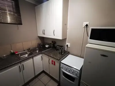 a small kitchen with a sink and a microwave at 94onWild in Pretoria