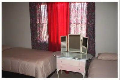 a bedroom with two beds and a table with a mirror at Cosy farmhouse for 4 persons in Lephalale