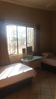a bedroom with two beds and a window at Confortable farmhouse in Limpopo Province in Lephalale