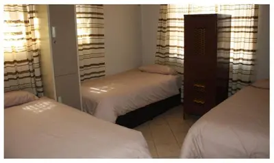 a bedroom with two beds and a mirror at 3 Single bedroom in farmhouse in Limpopo Province in Lephalale