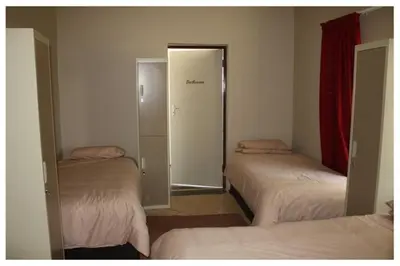 a room with three beds and a door to a closet at 3 Single bedroom in farmhouse in Limpopo Province in Lephalale