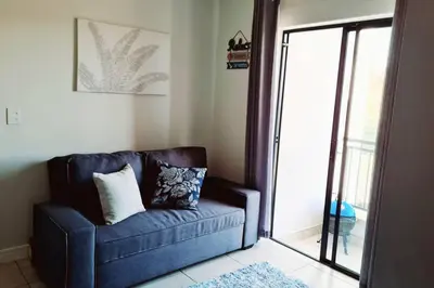 a blue couch in a living room with a sliding glass door at The Blyde - Little Place, Lots of Relaxation in Pretoria