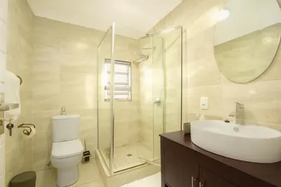 a bathroom with a toilet and a sink and a shower at Royal Hills Lodge and Spa in Thohoyandou