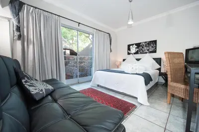 a bedroom with a bed and a couch at Interlude Guest House in Thabazimbi