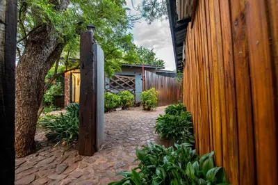 a backyard with a wooden fence and a stone walkway at Interlude Guest House in Thabazimbi