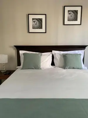 a large bed with white sheets and pillows at Spring Acres Apartment living in Nelspruit