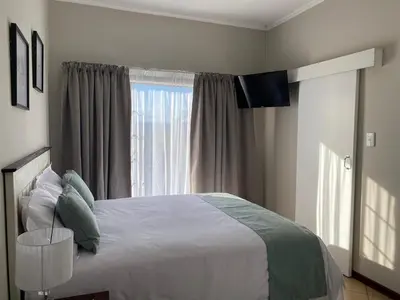a bedroom with a large bed and a window at Spring Acres Apartment living in Nelspruit