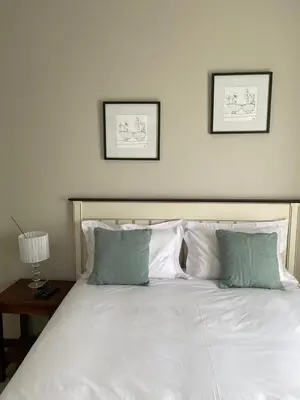 a large white bed with two pictures on the wall at Spring Acres Apartment living in Nelspruit