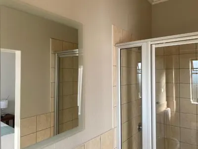 a bathroom with a shower and a mirror at Spring Acres Apartment living in Nelspruit
