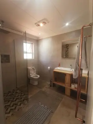 a bathroom with a toilet and a sink and a shower at SiriMiri Cottage Dullstroom in Dullstroom