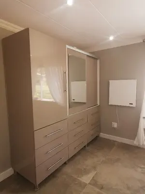 a bedroom with a large dresser and a mirror at SiriMiri Cottage Dullstroom in Dullstroom