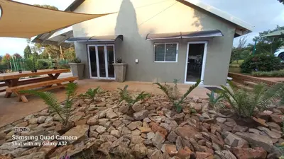 a building with a bench and a pile of rocks at SiriMiri Cottage Dullstroom in Dullstroom