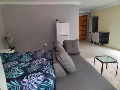 a living room with a couch and a tv at Moholoholo Lodge in Acornhoek