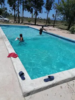 two people swimming in a swimming pool at Moholoholo Lodge in Acornhoek