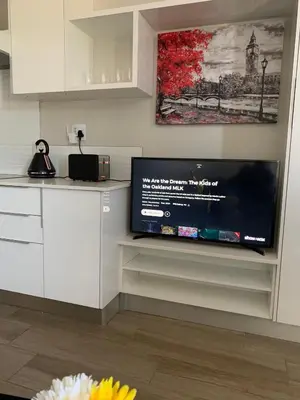 a kitchen with a flat screen tv on a wall at Regency Hotel Apartment @ 4th in Pretoria