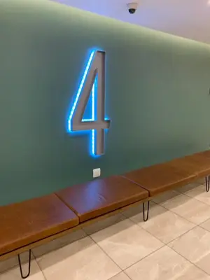 a neon number four sitting on a bench in a room at Regency Hotel Apartment @ 4th in Pretoria