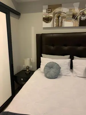 a bed with a black headboard and white pillows at Regency Hotel Apartment @ 4th in Pretoria