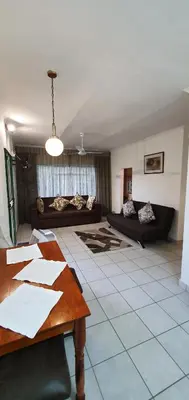 a living room with a table and a couch at Sister's Haven in Nelspruit
