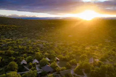 an aerial view of a resort with the sun setting in the background at Bundox Explorer Camp in Hoedspruit