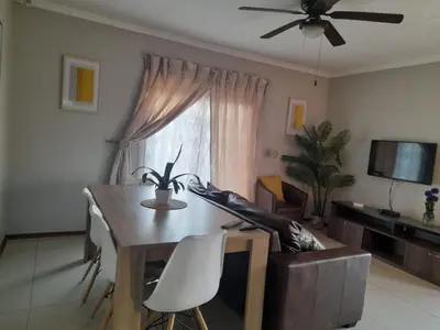 a living room with a table and a couch at Tumi's Home away- 3 Bedroom in Witbank
