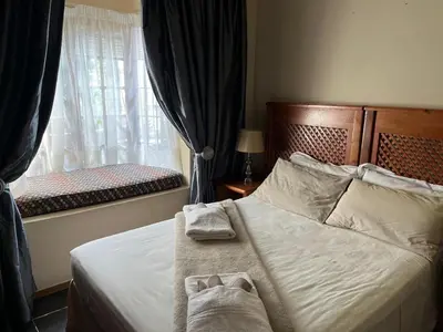 a bedroom with a bed with towels on it at Grace Place BnB Pretoria in Pretoria
