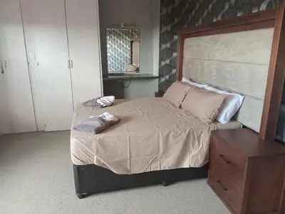 a bedroom with a large bed with two pillows on it at Grace Place BnB Pretoria in Pretoria