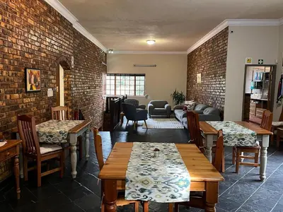 a restaurant with tables and chairs and a brick wall at Grace Place BnB Pretoria in Pretoria