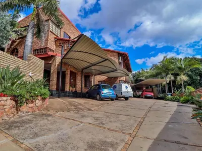 a building with a car parked in a parking lot at Grace Place BnB Pretoria in Pretoria