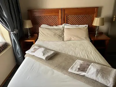 a bedroom with a bed with two towels on it at Grace Place BnB Pretoria in Pretoria