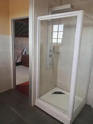 a shower with a glass door in a bathroom at Grace Place BnB Pretoria in Pretoria