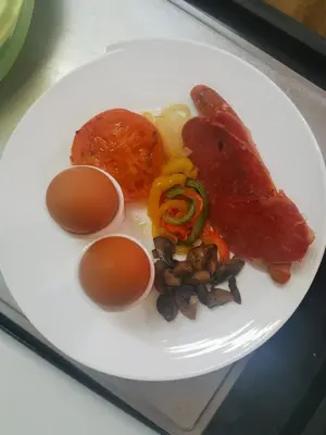 a white plate of food with eggs and meat at Grace Place BnB Pretoria in Pretoria