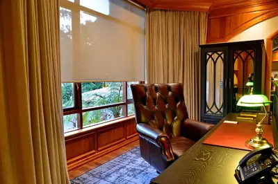 a room with a chair and a desk and a window at Apogee Boutique Hotel & Spa in Pretoria