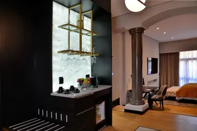 a living room with a fireplace and a bedroom at Apogee Boutique Hotel & Spa in Pretoria