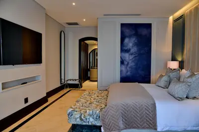 a bedroom with a large bed and a flat screen tv at Apogee Boutique Hotel & Spa in Pretoria