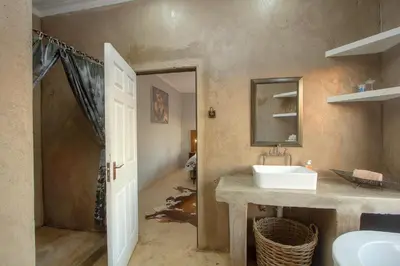 a bathroom with a sink and a mirror at Doornkom in Marloth Park