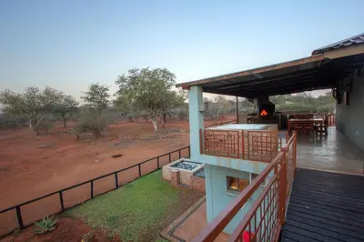 a porch of a house with a deck with a hot tub at Doornkom in Marloth Park