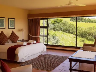 a bedroom with a bed and a large window at Amberley Mountain Reserve in Dullstroom