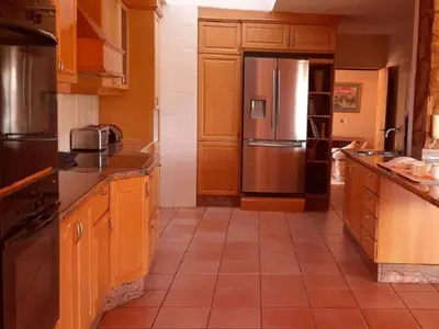 a kitchen with wooden cabinets and a stainless steel refrigerator at Amberley Mountain Reserve in Dullstroom