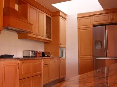 a kitchen with wooden cabinets and a black refrigerator at Amberley Mountain Reserve in Dullstroom