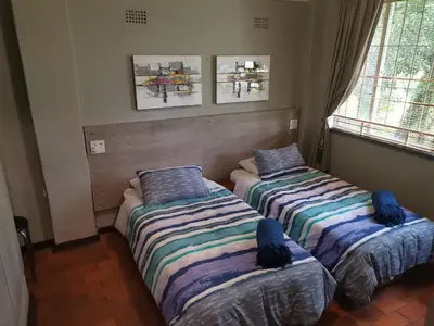 two beds sitting in a room with two windows at Karee Laagte in Leeuwfontein