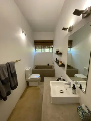 a bathroom with a sink and a toilet and a mirror at Birdsong Kruger in Marloth Park