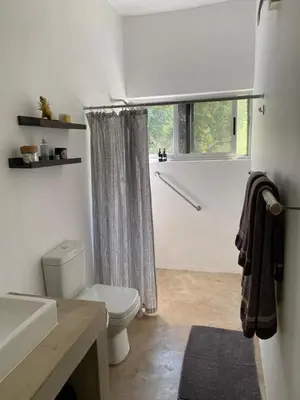 a bathroom with a toilet and a sink and a window at Birdsong Kruger in Marloth Park