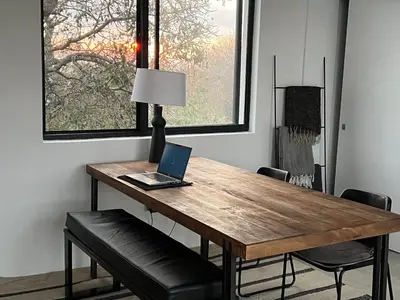 a wooden table with a laptop sitting on top of it at Birdsong Kruger in Marloth Park