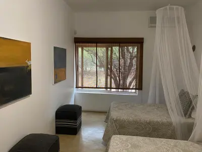 a bedroom with two beds and a window at Birdsong Kruger in Marloth Park